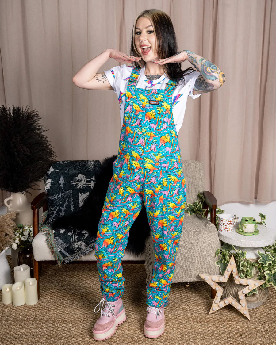 Woman wearing Run & Fly Rainbow Dinosaur Dungarees in a comfy lounge